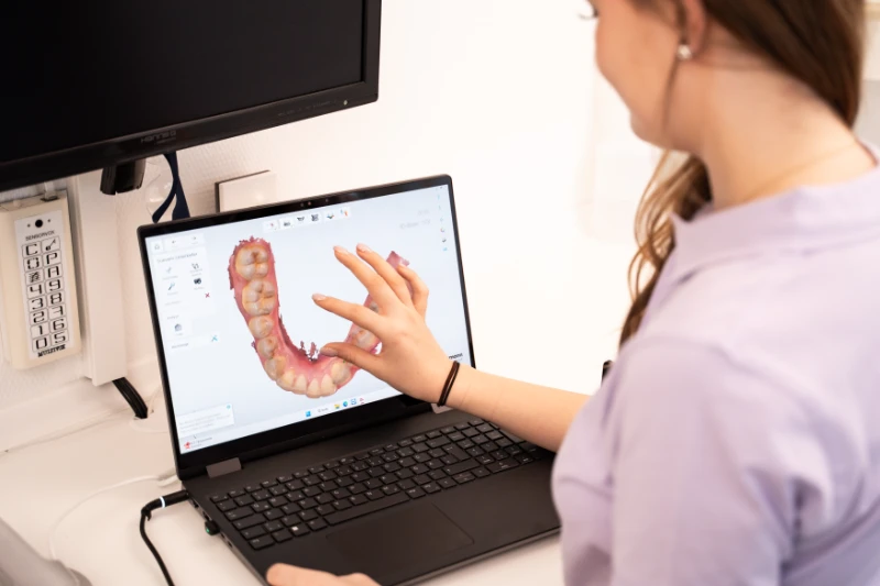 Das Bild zeigt eine ZFA mit einem Scan eines Kiefers auf einem Laptop